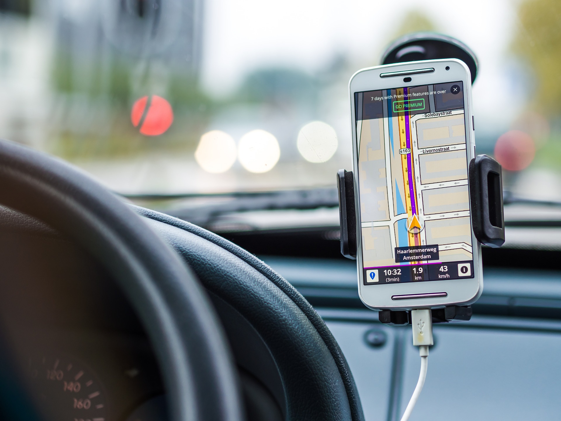An image that shows a phone mounted sideways of car steering showing navigation